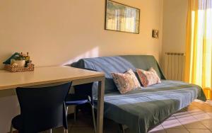 un canapé avec une table et une table et une chaise dans l'établissement 35 mq in centro a Caorle, à Caorle