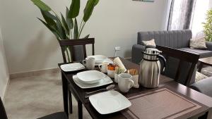 a table with plates and utensils on it in a living room at Mvule Homes in Arusha