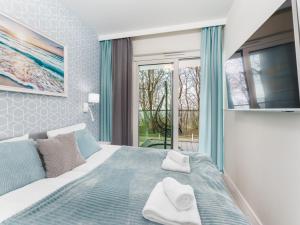 a bedroom with a bed and a large window at Apartament z Widokiem na Morze - Błękitna Perła by Perłowa Przystań Rent in Sianozety