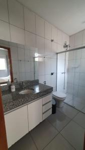 a bathroom with a sink and a toilet and a shower at Quintal da Canastra - Room in São João Batista do Glória