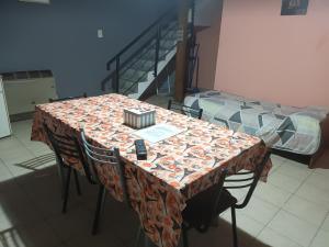 a table with chairs and a bed in a room at Departamento barrio Loma in Comodoro Rivadavia