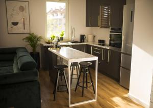 a kitchen with a counter and a table with stools at Apartament Wiśniewski - nad Jeziorem Drwęckim in Ostróda