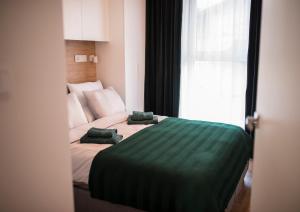 a bedroom with a bed with two green pillows on it at Apartament Wiśniewski - nad Jeziorem Drwęckim in Ostróda