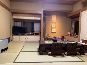 ein Wohnzimmer mit einem Tisch und Stühlen in der Unterkunft Kamuroan in Kyoto