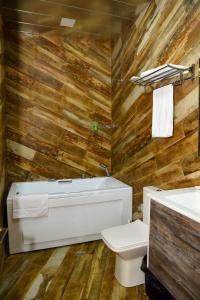 a bathroom with wooden walls and a tub and a toilet at BMG Hotel by Grigoryans Group in Goris