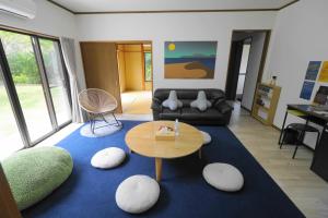 a living room with a table and a couch at 一棟貸しの宿 OKAYADO in Oshima