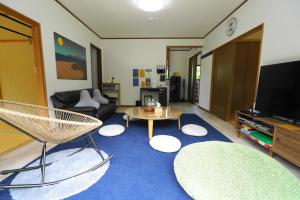 sala de estar con sofá y mesa en 一棟貸しの宿 OKAYADO, en Oshima