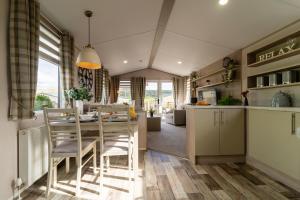 a kitchen and dining room with a table and chairs at Wiswell View Lodge: Pendle View Holiday Park in Clitheroe