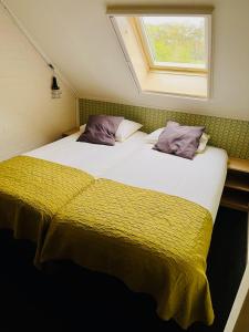 2 Betten in einem Zimmer mit Fenster in der Unterkunft De Veurdeale in Havelte