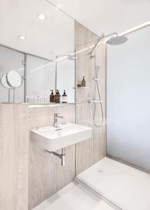 La salle de bains est pourvue d'un lavabo et d'une douche. dans l'établissement Hotel Golf Prague, à Prague
