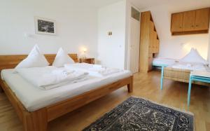 a bedroom with a bed with white sheets and a rug at Ferienwohnung Auch am Berg, Todtnauberg, Feldberg in Ennerbach