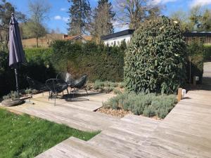 eine Terrasse mit einem Sonnenschirm, einem Tisch und Stühlen in der Unterkunft Chalet N°5 in Treignes