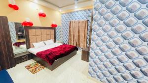 a bedroom with a bed and a wall with red balloons at Star hotel in Jabalpur