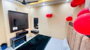 a room with a bed and a tv and red balloons at Star hotel in Jabalpur