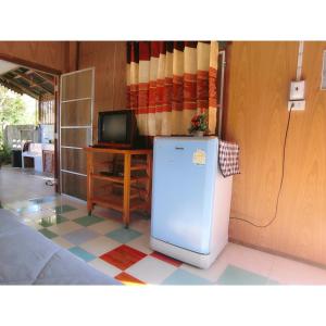 ein blauer Kühlschrank in einem Zimmer mit einem Fernseher in der Unterkunft Pernjai Homestay บ้านคำข้อน in Ban Lao