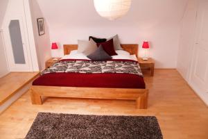 a bedroom with a large bed with red blanket and pillows at Haus Koenige Hinterzarten in Hinterzarten