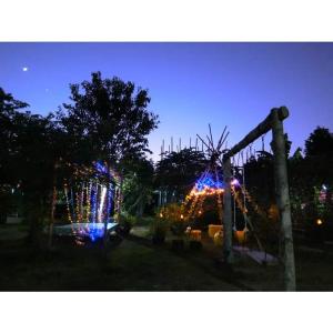 ein Spielplatz mit Weihnachtsbeleuchtung in einem Hof bei Nacht in der Unterkunft Pernjai Homestay บ้านคำข้อน in Ban Lao