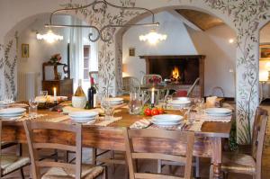 comedor con mesa con sillas y chimenea en Tenuta di Casaglia, en Podere Colombaie