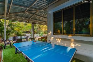 un tavolo da ping pong blu su un patio di EKO STAY- CASA POLO Villa ad Alibaug
