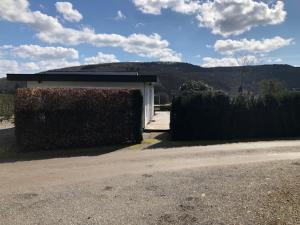 ein Gebäude mit einer Hecke neben einer Straße in der Unterkunft Chalet N°5 in Treignes