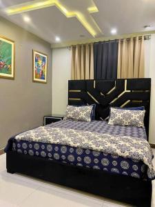 1 dormitorio con 1 cama con edredón azul y blanco en 401-NEXT INN Quality Living Starts Here! en Lahore