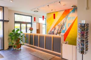 a lobby with a colorful mural on the wall at H+ Hotel 4Youth in Berlin