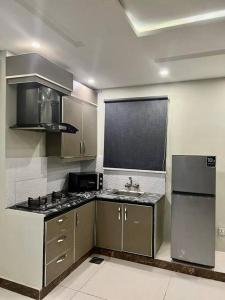 a kitchen with a sink and a refrigerator at 401-NEXT INN Quality Living Starts Here! in Lahore