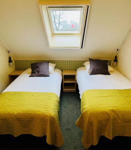 two beds in a small room with a window at De Veurdeale in Havelte