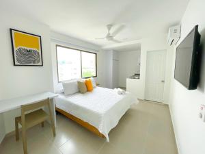 Habitación blanca con cama y escritorio en Magico Apartaestudio con Piscina 1 Habitacion PR66A en Montería