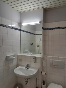 uma casa de banho com um lavatório, um espelho e um WC. em Best Western Comfort Business Hotel Düsseldorf-Neuss em Neuss