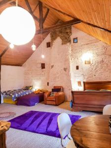 Cette chambre comprend deux lits, un canapé et une table. dans l'établissement La Maison des Hirondelles Forêt de Brocéciande, à Saint-Malon-sur-Mel