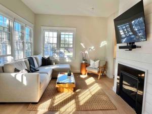 a living room with a couch and a fireplace at Luxury Water-View West End Condo in Provincetown
