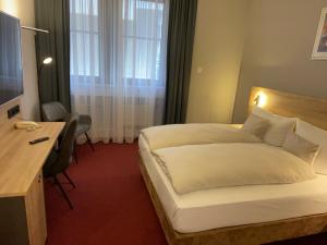 um quarto de hotel com uma cama grande e uma secretária em Best Western Comfort Business Hotel Düsseldorf-Neuss em Neuss