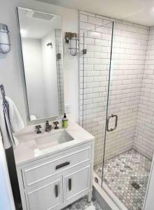 a white bathroom with a sink and a shower at Luxury Water-View West End Condo in Provincetown