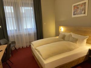 una camera da letto con un grande letto bianco e una finestra di Best Western Comfort Business Hotel Düsseldorf-Neuss a Neuss
