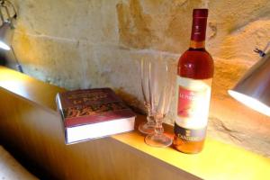 a bottle of wine and a book and glasses on a counter at Colori Salentini Appartamento CORALLO in Sant'Isidoro