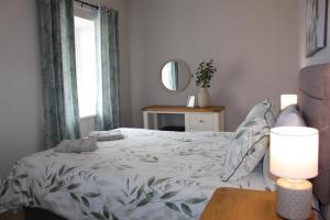 a bedroom with a bed and a window and a table at Sunrise Cottage in Llanddulas