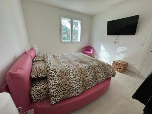 1 dormitorio con cama rosa y TV de pantalla plana en Villapinetacervia en Cervia