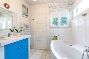 Baño blanco con bañera y lavamanos en GuestReady - A happy place to stay in Paris, en París