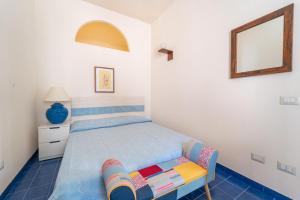 a small bedroom with a bed and a mirror at Burantì Guest House in Alghero