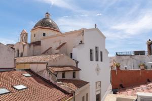 a view of roofs of buildings with a cathedral in the background at Burantì Guest House in Alghero