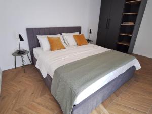 a bedroom with a large bed with orange pillows at Sea View Apartments Ivana in Krk