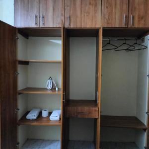 a closet with wooden cabinets and a phone in it at CND Luxury Homes in Mombasa