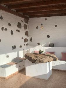 a bedroom with a bed with rocks on the wall at Sunset Terrace in La Oliva