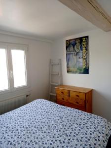 ein Schlafzimmer mit einem Bett und einem Bild an der Wand in der Unterkunft Chez Sophie in Trouville-sur-Mer