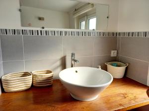 ein Badezimmer mit einem weißen Waschbecken auf einer Holztheke in der Unterkunft Chez Sophie in Trouville-sur-Mer