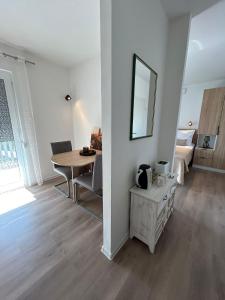 een witte woonkamer met een tafel en een spiegel bij Villa Dražana in Gradac
