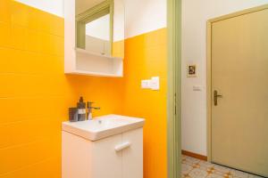 een gele badkamer met een wastafel en een spiegel bij Pied a Terre Taormina mare in Taormina