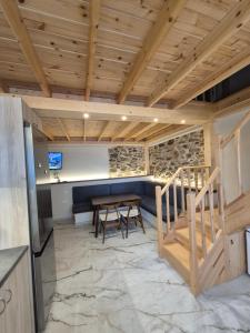 a kitchen and dining room with a wooden ceiling at Ελιά Ξενώνας / Elia Xenonas in Mytilene