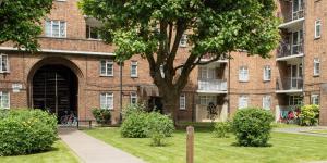 a brick building with a tree in front of it at Modern Flat in Maida Vale in London